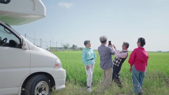 亚洲中国活跃的老年人在露营车汽车之家前欣赏风景稻田
