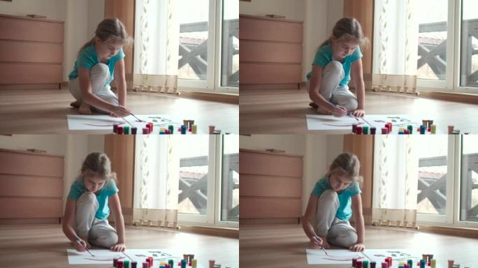 白人女孩玩得开心，在纸上画画，是创造性的艺术家。孩子在客厅的纸上画彩色颜料。孩子在家画画孩子创造力灵
