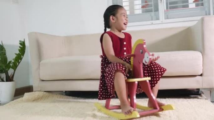 亚洲可爱小女孩摇摆骑玩具马