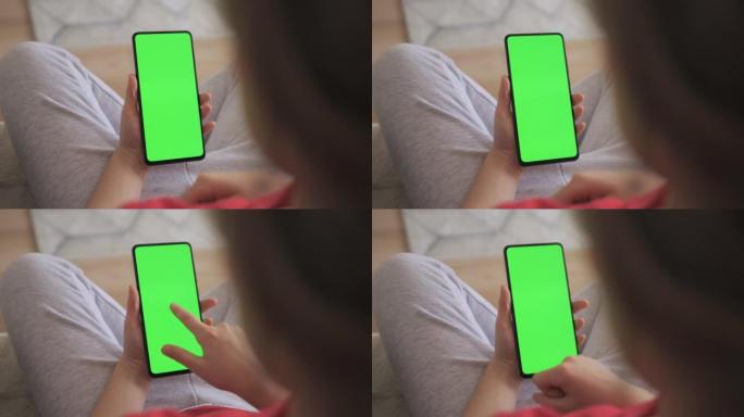 儿童在客厅使用带有绿色模型的电话的观点。手机与绿色模拟屏幕色度键上网观看内容视频博客学习。玩电子游戏