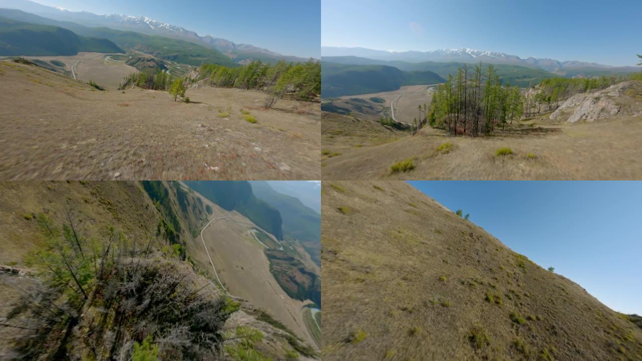 FPV运动无人机在风景如画的秋春自然景观丘陵地形上飞行