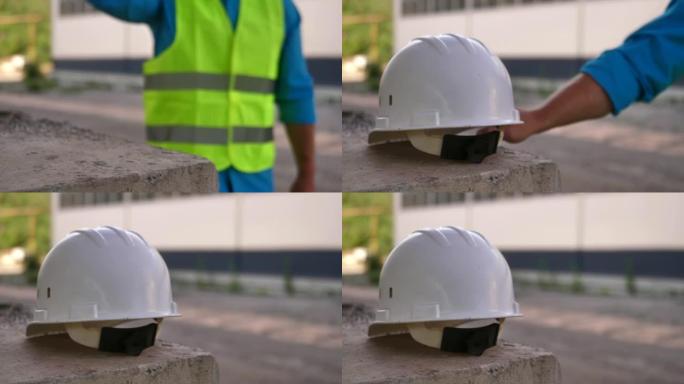 一名建筑工人的特写镜头，在一座在建桥梁的钢筋混凝土桥墩上留下了一顶保护性的白色安全帽。建筑工人在建筑
