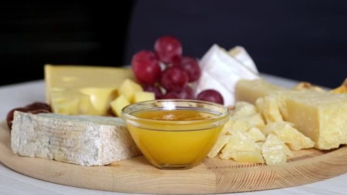 奶酪盘配卡门培尔布里帕尔马干酪荷兰奶酪。西班牙或意大利开胃小吃，奶酪，坚果，面包，葡萄，枣，无花果。