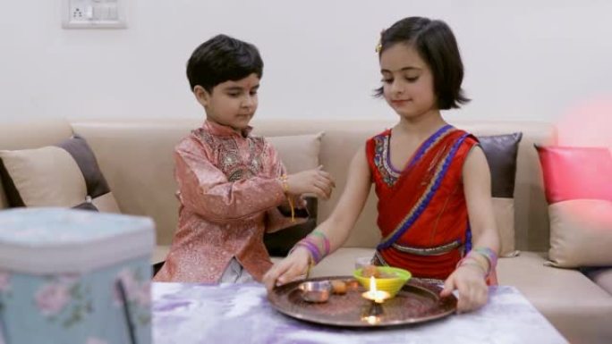 印度兄弟姐妹在家里快乐地庆祝罗刹班丹节-印度节，庆典，印度家庭