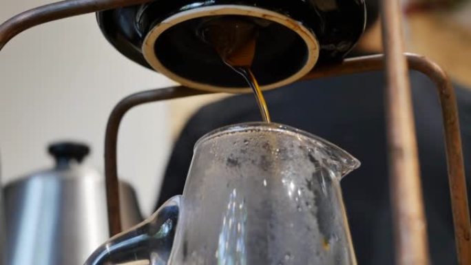 在准备咖啡师的过程中，热流的浓缩咖啡从羊皮纸过滤器流入玻璃罐中。过滤咖啡饮料
