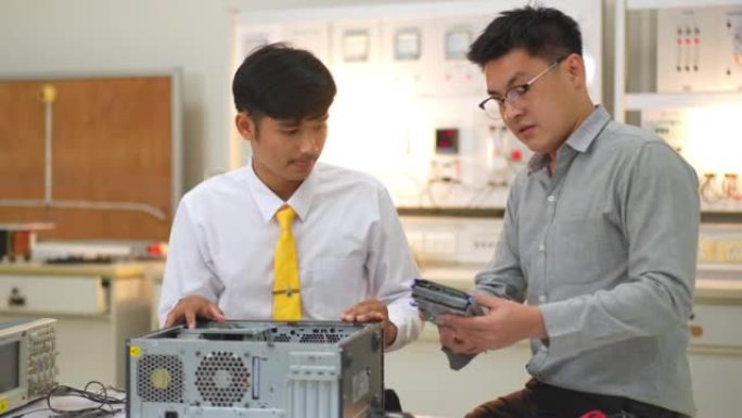 亚洲学生向电子技师老师学习拆卸和固定主板进行清洁。电脑维修。从板上移除处理器