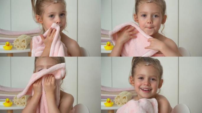 女孩用柔软的毛巾布擦湿脸。洗澡后快乐的孩子。婴儿护理