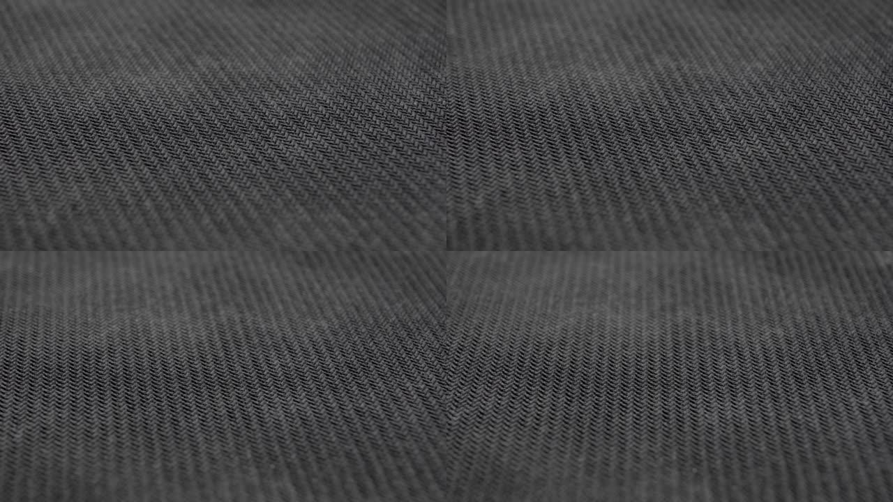 黑色纺织垃圾编织材料。深色尘土纹理织物特写。机织结构。宏