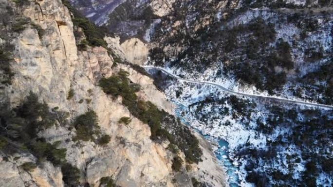 鸟瞰图的陡峭的悬崖，罕见的杜松和清澈的碧绿的河水在冬季的山区。自然自然中的山地和清洁水的来源