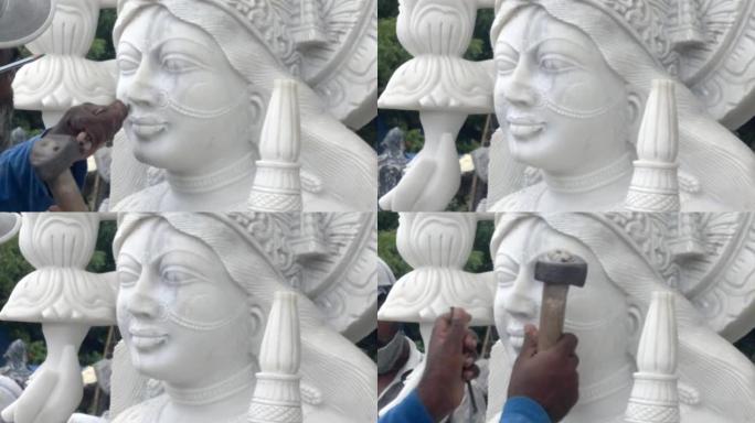 印度工匠雕刻传统印度教女神拉克希米或拉克希米白色大理石雕塑或雕像出售，使用锤子和凿子，手移动。