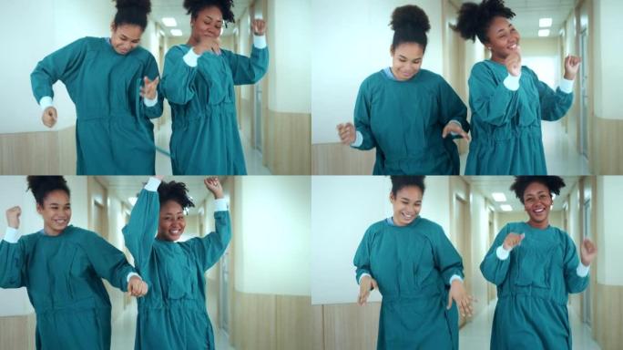 快乐的非洲裔美国护士和助手在医院走廊里散步时跳舞。医务人员享受。