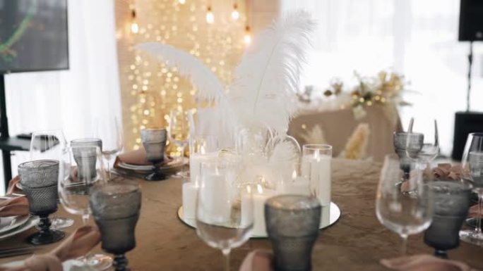 庆典时的桌子上装饰着大羽毛。有盘子等着客人