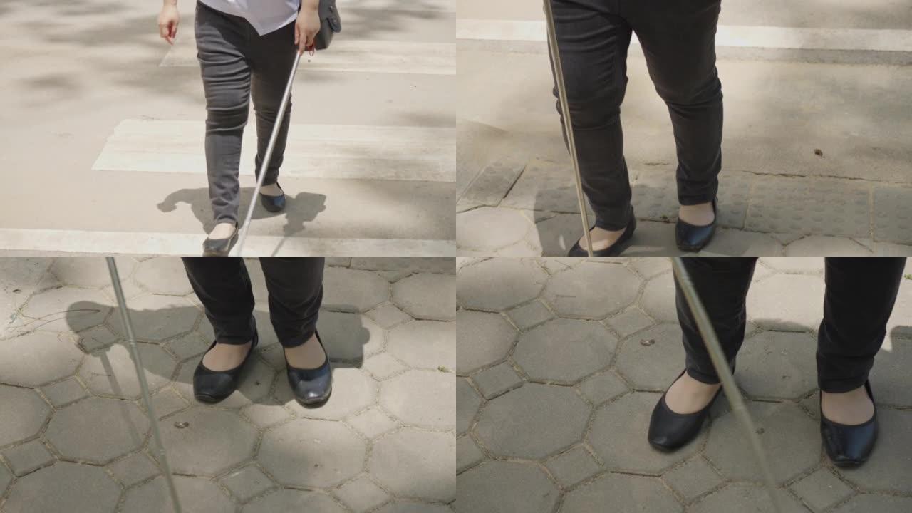失明残疾的妇女在人行横道上行走，并使用盲目的白色拐杖在人行道上找到盲文块或触觉铺路。