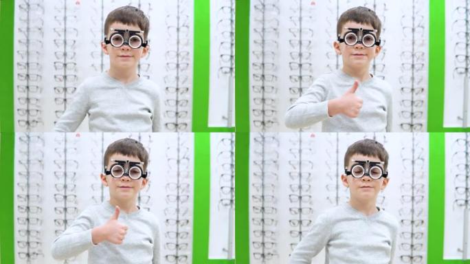 小男孩站在带有眼镜镜框的橱窗的背景上，并带有用于选择隐形眼镜的装置