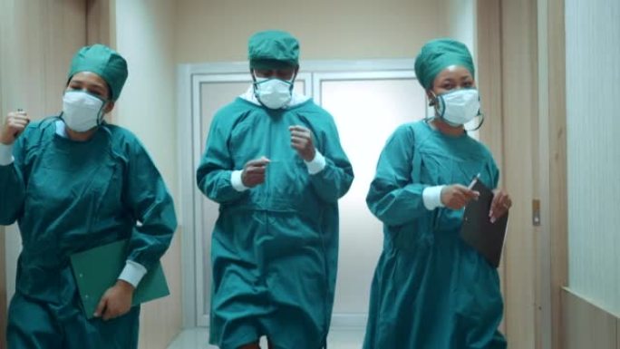 由医生，护士和助手组成的快乐的非裔美国人团队在医院的走廊中跳舞。医务人员享受。