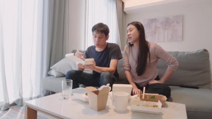 东南亚夫妇在他们的公寓里吃送来的食物