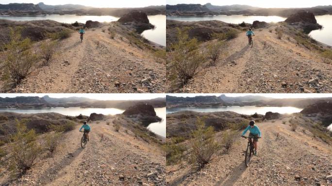 成熟女子山地自行车手登上沙漠小径