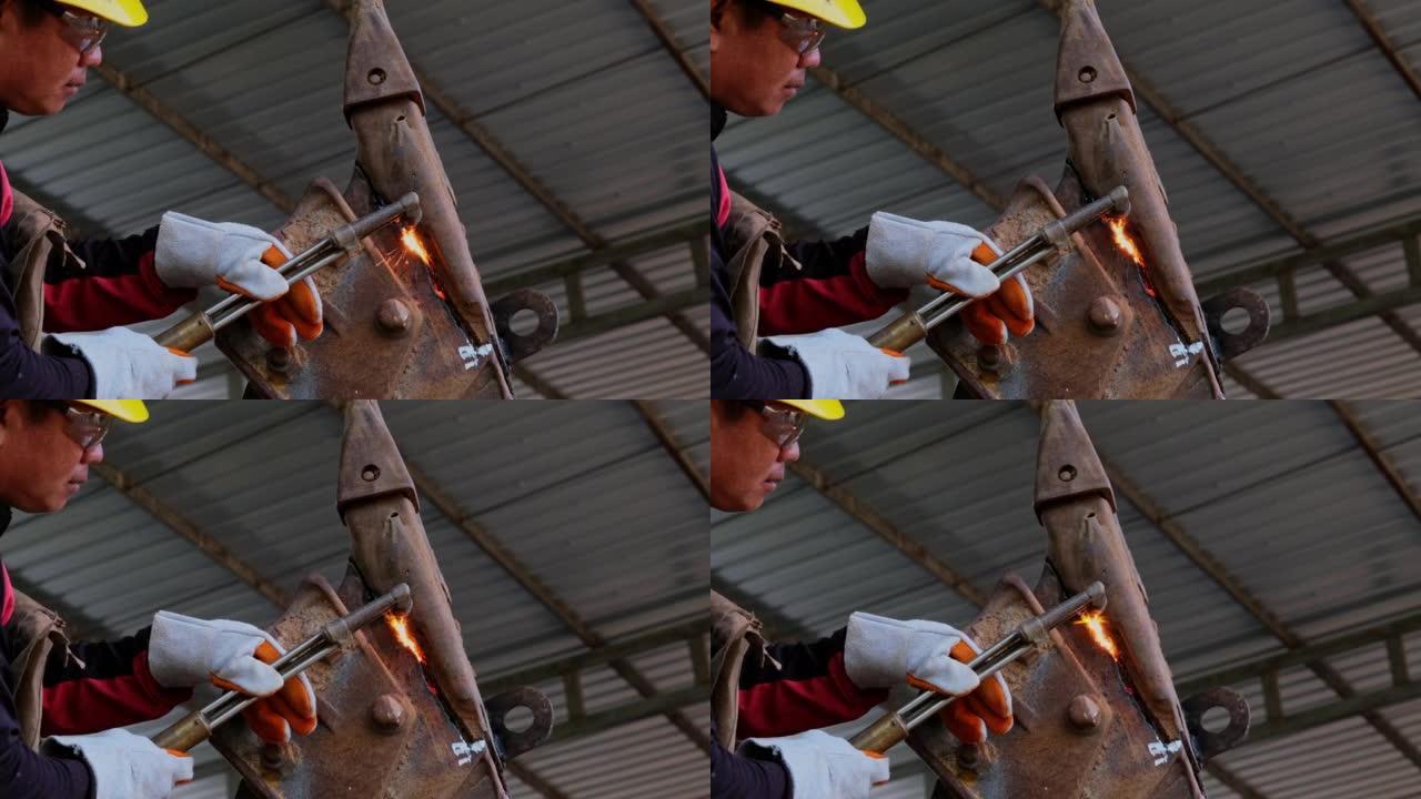 工人用煤气枪切割钢材。用丙烷和氧气切割钢。使用燃料气体和氧气焊接和切割金属的工艺。
