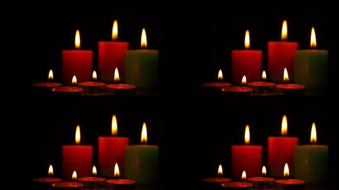 在黑色背景上燃烧的香薰蜡烛。蜡烛在黑暗中燃烧，香气和放松。