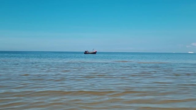远处，一艘小渔船在大海或海洋中航行