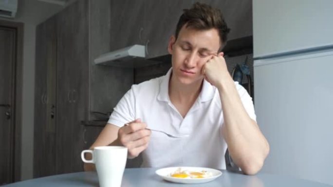 昏昏欲睡的人在厨房里吃早餐和喝咖啡