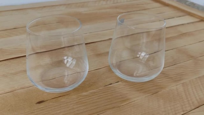 Two empty glasses for whiskey or cognac on a woode