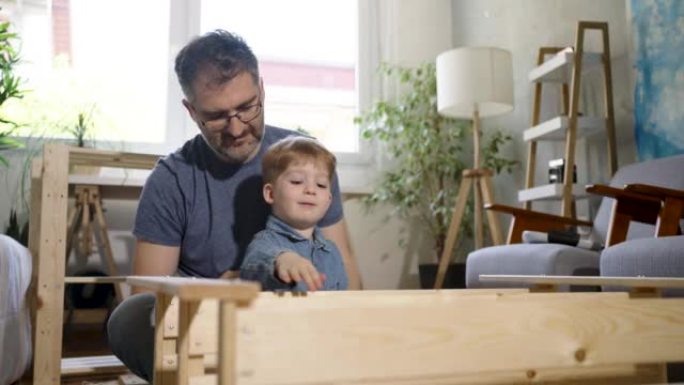 父子俩一起组装新的木制家具