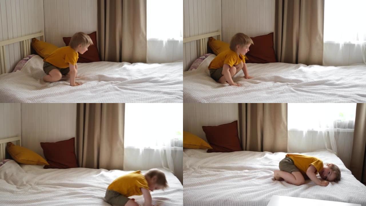 有趣、开朗、可爱的金发小男孩醒来，在床上跳高。顽皮的孩子独自在家玩得开心。简单的幸福。情绪化的蹒跚学