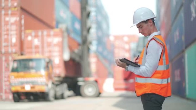 货物集装箱工人用平板电脑检查和监控进出口运输，卡车在后台工作