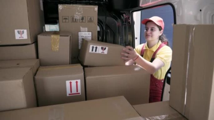 女送货员卸下装满包裹的货车。