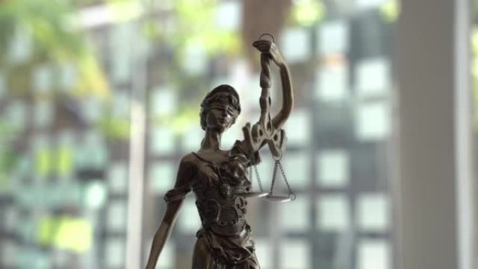 木制背景上的正义雕像。法律法律、建议和正义的概念