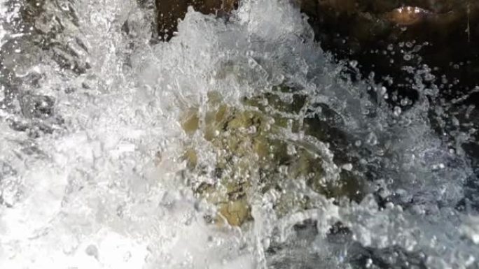 水晶清澈的山水在慢动作中坠落在岩石上