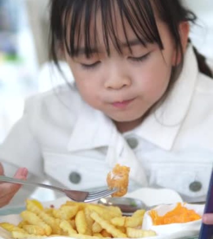 肖像小女孩在餐馆吃炸薯条