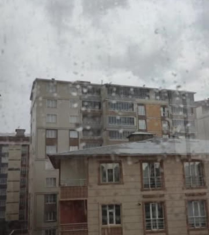 雨滴从公寓的窗户流下，美丽的水滴，雨水溅到窗户上，窗外雷雨，水从玻璃上流下。