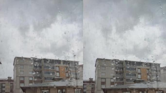 雨滴从公寓的窗户流下，美丽的水滴，雨水溅到窗户上，窗外雷雨，水从玻璃上流下。