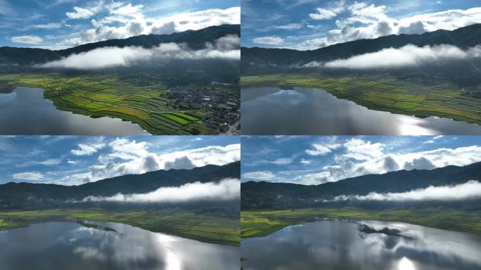 山腰间云雾缭绕映衬着金色稻田和蓝色湖泊