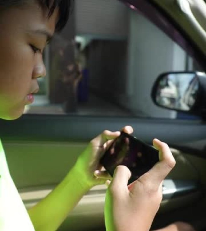 特写，手机男孩在车里玩手机