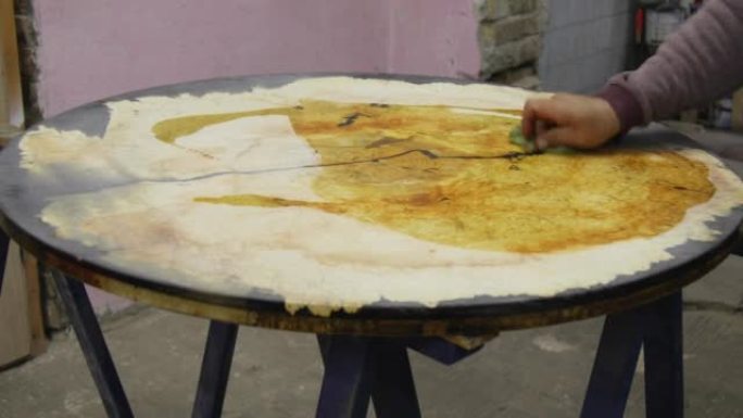 木匠用亚麻籽油涂覆木质环氧桌子