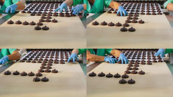 糖果厂的工人从传送带上拿走了巧克力棉花糖。在工厂包装甜品。特写。