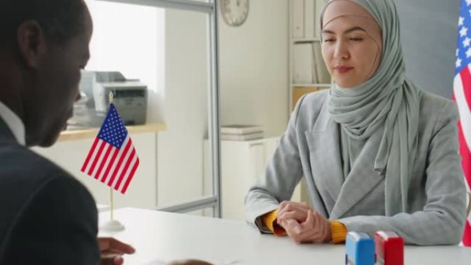 戴头巾的妇女在大使馆申请美国签证