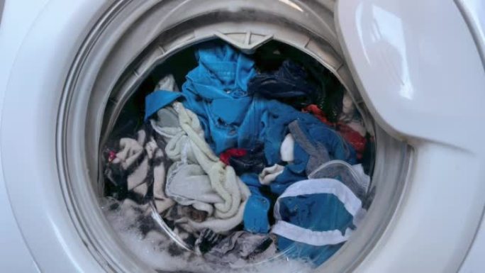 家用洗衣机洗衣服。旋转滚筒洗衣机的特写视频。高质量全高清镜头