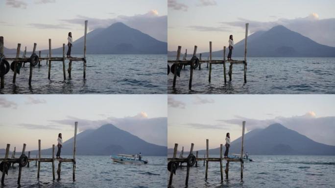 日落时危地马拉阿蒂兰湖码头上的女人