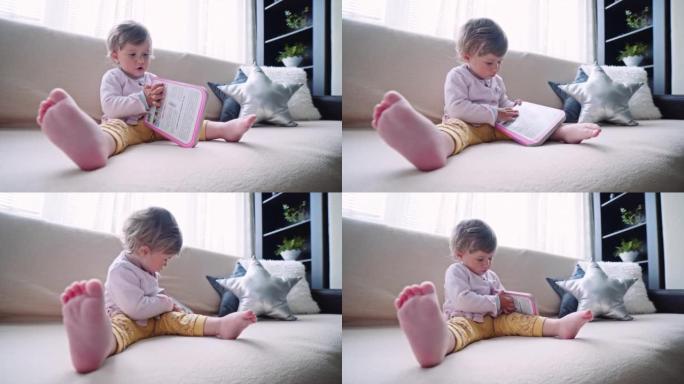 婴儿在沙发上看书，浏览图像。