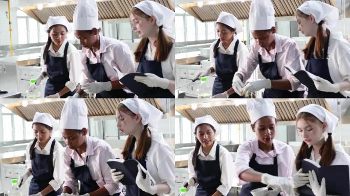 在书上记笔记。烹饪课。烹饪教室。一群快乐的年轻女子多民族学生正在烹饪学校专注于烹饪课程。