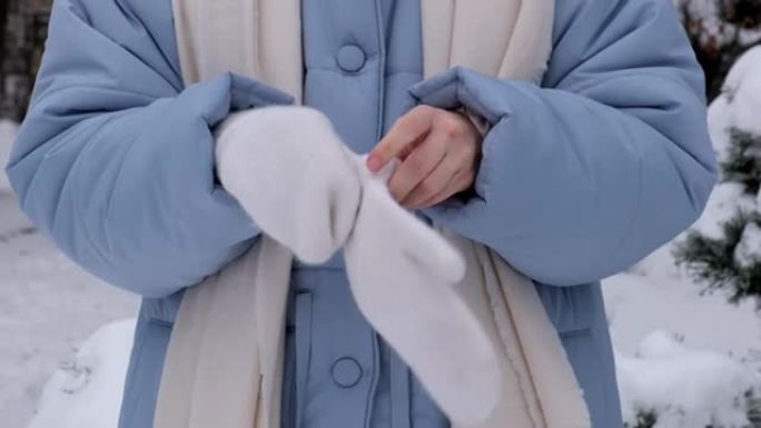 女人在寒冷的冬日戴上白手套