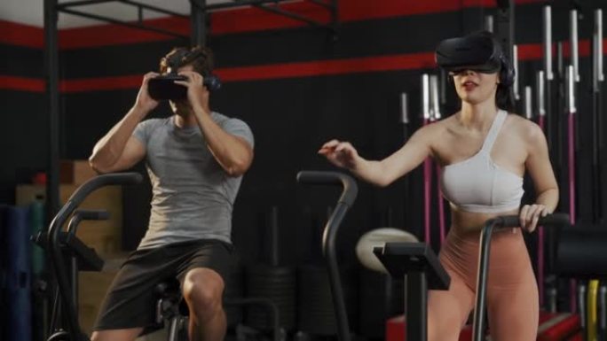 Asian man and woman wearing VR headset and cycling