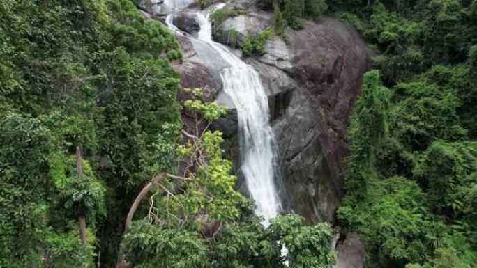 在马来西亚吉打州兰卡威的Telaga Tujuh瀑布中穿越热带森林的树叶。空中无人机射击