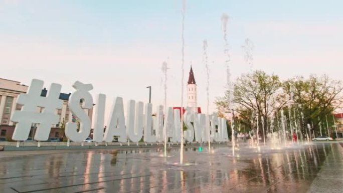 立陶宛Siauliai-5月27日，2021: Siauliai城市广场，在美丽的日落背景下有喷泉。