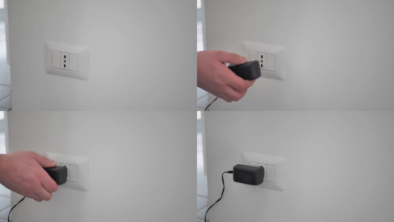 手动将黑色电源线电缆手机充电器图表插入墙上的电插座。准备连接插头。节能或降低成本的概念