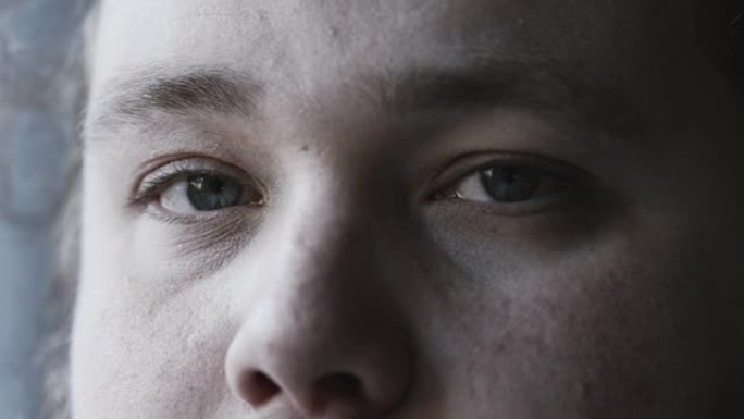 一个年轻人极端的眼睛近距离凝视着带微距镜头的相机